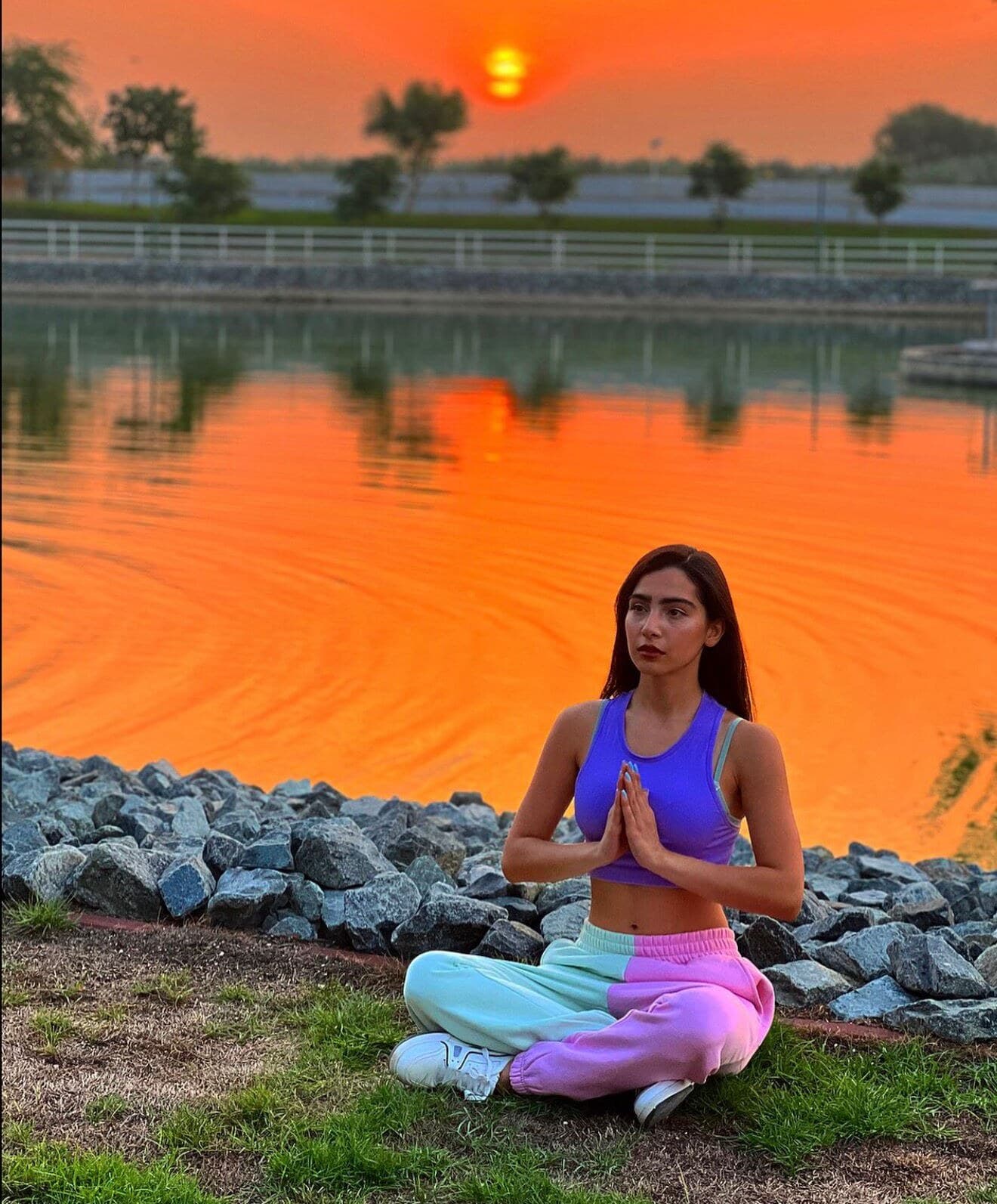 A guest meditating by the lake at sunset at Nirvana Retreat, Ras Al Khaimah
